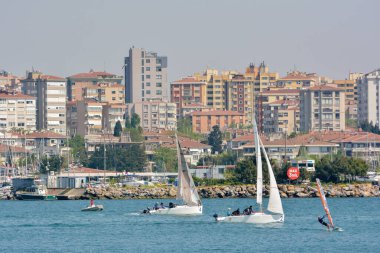 ISTANBUL, TURKEY, MAY 1, 2013: Wind surfers and sail boats near Kalamis coastline, a neighborhood on the bay of the same name in the district of Kadkoy on the Anatolian side of Istanbul, Turkey.