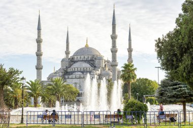 ISTANBUL, TURKEY, SEPTEMBER 2, 2013: People sitting around the fountain at Sultanahmet Square, Sultan Ahmet Mosque can be seen at the background. Sultanahmet District is the heart of old Istanbul.