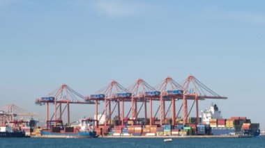 Mersin, TURKEY, 2 Mayıs 2023: Türkiye 'nin Mersin kentindeki Akdeniz' in kuzeydoğu kıyısında yer alan büyük bir liman olan Mersin Uluslararası Limanı 'ndaki konteynır gemisine yük taşıyan vinçler.