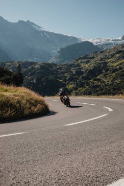 Sustenpass, İsviçre - 3 Ağustos 2022: Sustenpass yolunda motosiklet sürmek, Berna Canton 'da, arka planda Stein Buzulu, İsviçre Alplerinde.