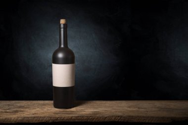 Mükemmel kırmızı şarap şişeleri, şarap bardağı, fıçı ve tirbuşon kırsal bir masa üzerinde: geleneksel şarap yapımı ve şarap tatma konsepti. Yüksek kalite fotoğraf