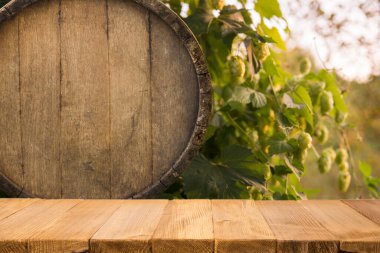 Bir kupa bira, buğday kulağı, yeşil zıpır ve ahşap bir arka planda bira fıçısı. Yüksek kalite fotoğraf