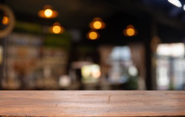 Boş ahşap masa üstü ve gece karanlığında cafe restoranının bulanıklığı. Yüksek kalite fotoğraf