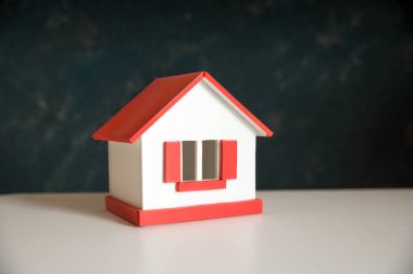 Kışın ev - ısıtma sistemi konsepti ve soğuk karlı hava ve örgü şapkalı bir ev modeli. Yüksek kalite fotoğraf