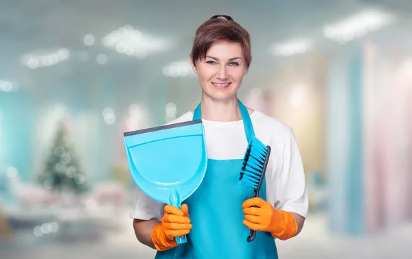 一位清洁女工拿着清洁工具站在除夕夜的内部 — 图库照片