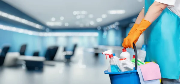 コンセプトクリーニングサービス事業所 ビジネスセンターのオフィスを背景に商品を洗浄するバケツを持っている清掃女性 — ストック写真