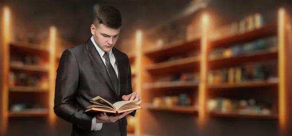 Junger Mann Anzug Liest Vor Verschwommenem Hintergrund Der Bibliothek Ein — Stockfoto