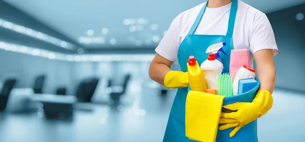 Temizlikçi Kadın Arka Planda Bir Kova Temizlik Ürünleriyle Duruyor — Stok fotoğraf