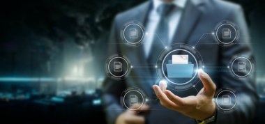 Businessman showing database structure with files on blurred background.