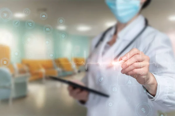 Concept of modern technology in medical practice. Doctor draws pulse on virtual computer screen.