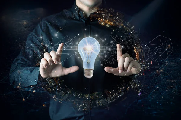 Concept idea innovation modern technology. A businessman shows a burning light bulb in the background.