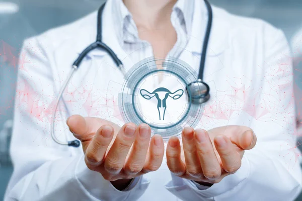 Doktor bulanık arka planda uterus simgesini destekler.