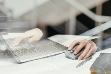 Programcı ofisteki bir masada dizüstü bilgisayarda çalışıyor..