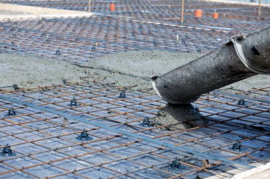 Beton makinası betonu birleştirir. Beton tepsiden takviyeye dökülür..