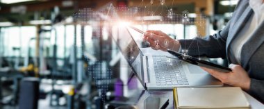 Müdür sanal bir bilgisayar ve dizüstü bilgisayar kullanarak ofiste çalışır..