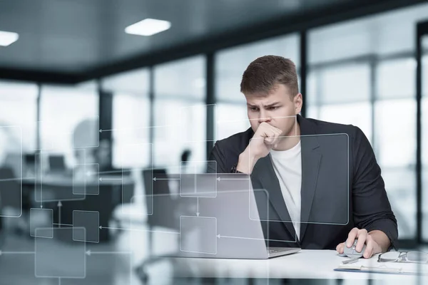 Male software developer sitting at laptop virtual computer on blurred background.
