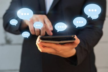 Bir iş adamı bulanık bir arkaplanda tablet üzerinde sohbet ediyor..