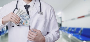 Doktor arka cebine bulanık bir arka plan için dolar koyuyor..