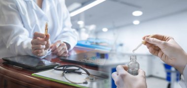 İlaçlar üzerinde laboratuvar testi yapma kavramı. Pipeti olan bir laboratuar asistanı ve elinde ampul olan bir doktor..