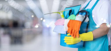 Temizlik servisi kavramları. Kovalı ve temizlik malzemeli üniformalı bir kadın..