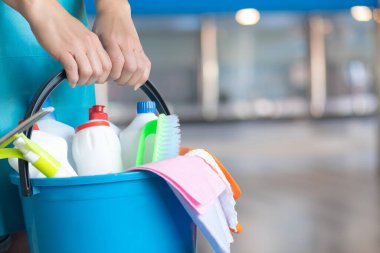 İçerisinde bir kova temizlik malzemesi olan profesyonel bir temizlikçi. Temizlik hizmetleri kavramı.