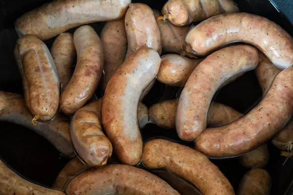 Stock image The process of cooling grilled sausages in water. Stages of sausage preparation.