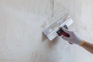 Duvarı bir spatulayla kaplama konsepti. Bir duvara macun sürme kavramı.