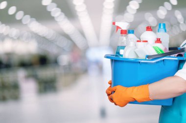 Temiz ve düzenli. Koruyucu eldiven giyen bir işçinin elinde bir kova temizlik malzemesi tuttuğu bir temizlik süreci..