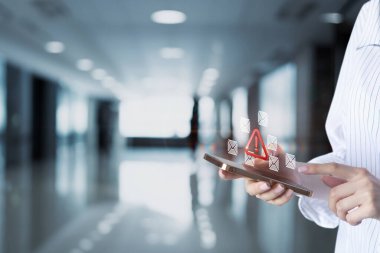 Bir kişi, uyarı ve tebligat gösteren bir akıllı telefonla iletişim kurar. Modern ortam, parlak bir yüksek teknoloji ortamının bulanık bir arka planına sahip..