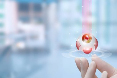 Bir doktorun eli lazer ışını kullanarak göz tarama prosedürünü gösteriyor. Ayarlar modern ve klinik görünüyor, gelişmiş tıbbi teknolojiyi kullanımda vurguluyor.