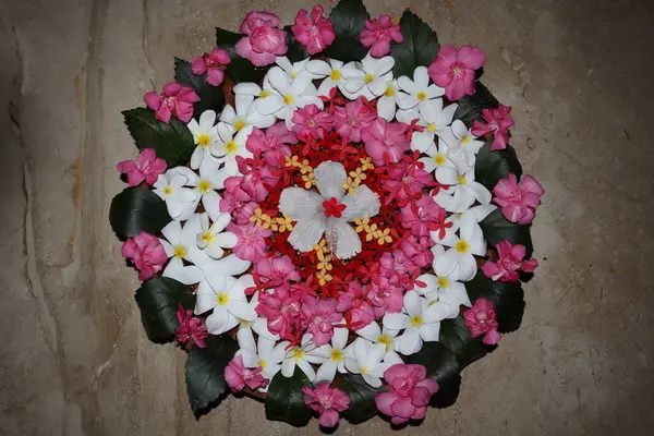 Beautiful Floating flower decorations done in large clay flat pot. Flower decoration in water with Plumeria and Oleander flowers with Hibiscus in center. Decoration for festival at home