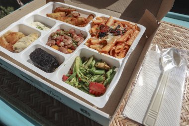 Avrupai ya da amerikan yemek tabağı parseli. Makarna, çıtır salata, browni, soslu patates dilimleri.