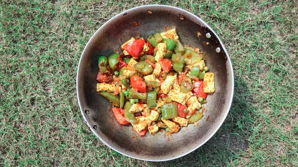 Lezzetli Paneer biberli sebze kızartması. Ev yapımı süzme peynir tabağı sotelenmiş yeşil ve yeşil bezelyeli kırmızı dolma biber.