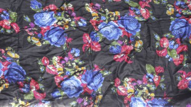 Siyah arka planda güzel bir ipek şal. Çok renkli çiçek desenli kumaş arkaplanı çalınmış