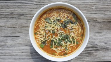 Beyaz zemin üzerinde şeffaf kâse içinde sarı hardal tohumları.