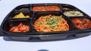 Tasty Asian platter consisting of veg fried rice, chilli garlic noodles, manchurian dry, veggies in hot garlic sauce, kimchi and chocolate brownie clipart