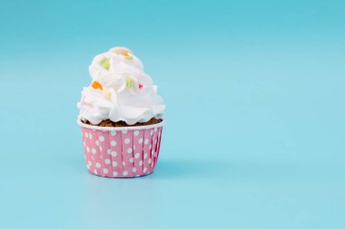 Tasty cup cake on blue background with copy space