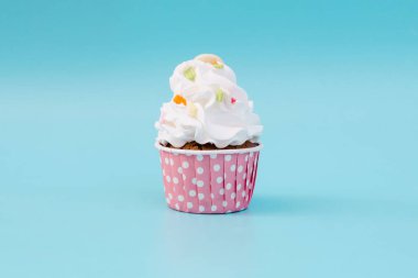 Tasty cup cake on blue background with copy space