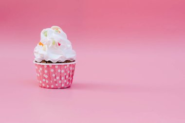 Tasty cup cake on pink background with copy space