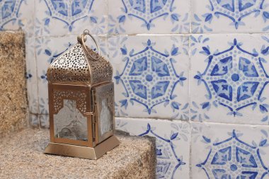 Decorative Moroccan lantern on stone stairs. Vintage blue Moroccan tiles. Portuguese azulejos. Decorative wall. Festive banner, still life for muslim holiday Ramadan Kareem, Eid ul Fitr, Eid al Adha.