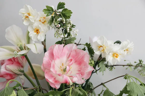 stock image Spring bridal bouquet of mixed garden flowers on vintage gray wall background behind. Closeup of pink tulip, daffodils and green guelder rose branches. Selective focus. Wedding, birthday. Mothers day.