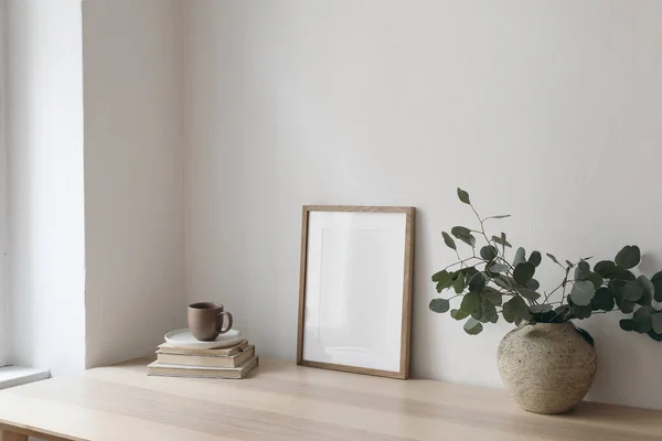 一杯咖啡 木制桌子 桌子上的空的垂直画框 用银桉树枝条盛开 最小的工作空间 家庭办公室 斯堪的纳维亚室内设计 侧视图 — 图库照片