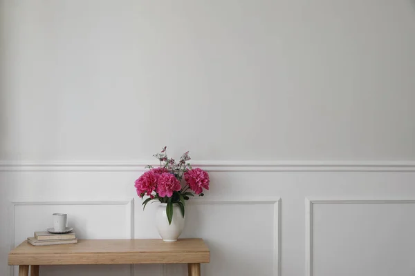 エレガントなインテリアは静物画です ピンクの牡丹の花で花瓶 本のコーヒーのカップ 木製のテーブル ロマンチックな朝食 最小限の素朴な家 リビングルーム 空の白い壁の背景 — ストック写真