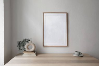 Noel dekore edilmiş iç mekan. Çam ağacı dalları olan eski kitaplardaki modern vazolar. Bej masa üzerine bir fincan kahve. Ahşap çerçeve modeli. Beyaz duvar arka planı, minimum modern İskandinav evi.