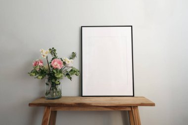 Easter springtime still life. Blank black picture frame mockup on wooden bench, table. Spring bouquet of pink tulips, white daffodils, hawthorn flowers, pastel green, mint wall background. clipart