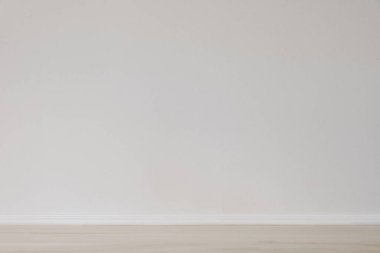 Modern iç mimari. Boş bej ahşap zemini ve boş beyaz duvarı olan basit bir arkaplan. İskandinav evi. Yer, ürün sergisi için yer, ev. Daire. Kapalı mimari kavramı.