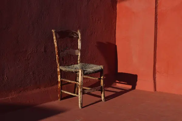古老的木制椅子 房间里有红墙 地板上有阳光 黑暗的阴影 破旧的古董家具 空虚的复制空间 没有人 复古的内心静谧的生命 — 图库照片#