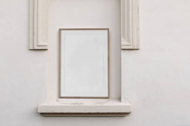 Boş dikey ahşap çerçeve, poster modeli. Klasik sütunları olan zarif bir yer. Eski binanın mimari sıva ayrıntıları. Chambranle, dekoratif çıkıntı, bej renkli güzel bir cephe dekoru.