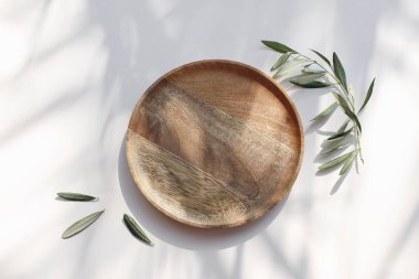 Yaz düğünü hala hayattadır. Tahta tabak, güneş ışığı tepsisi. Beyaz masa arkasında zeytin dalları. Güneş ışığı. Gölge çiçekli örtüler, benekli ışıklar, şenlikli masa düzenlemeleri. Düz yatıyordu. Üst görünüm.