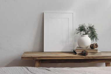 Noel evi dekorasyonu. Boş tebrik kartı, davetiye kâğıdı modeli. Eski ahşap konsol masası. Modern vazo, çam ağacı dalları. Kağıt noel baloları. Beyaz duvar arka planı, İskandinav iç mimarisi.